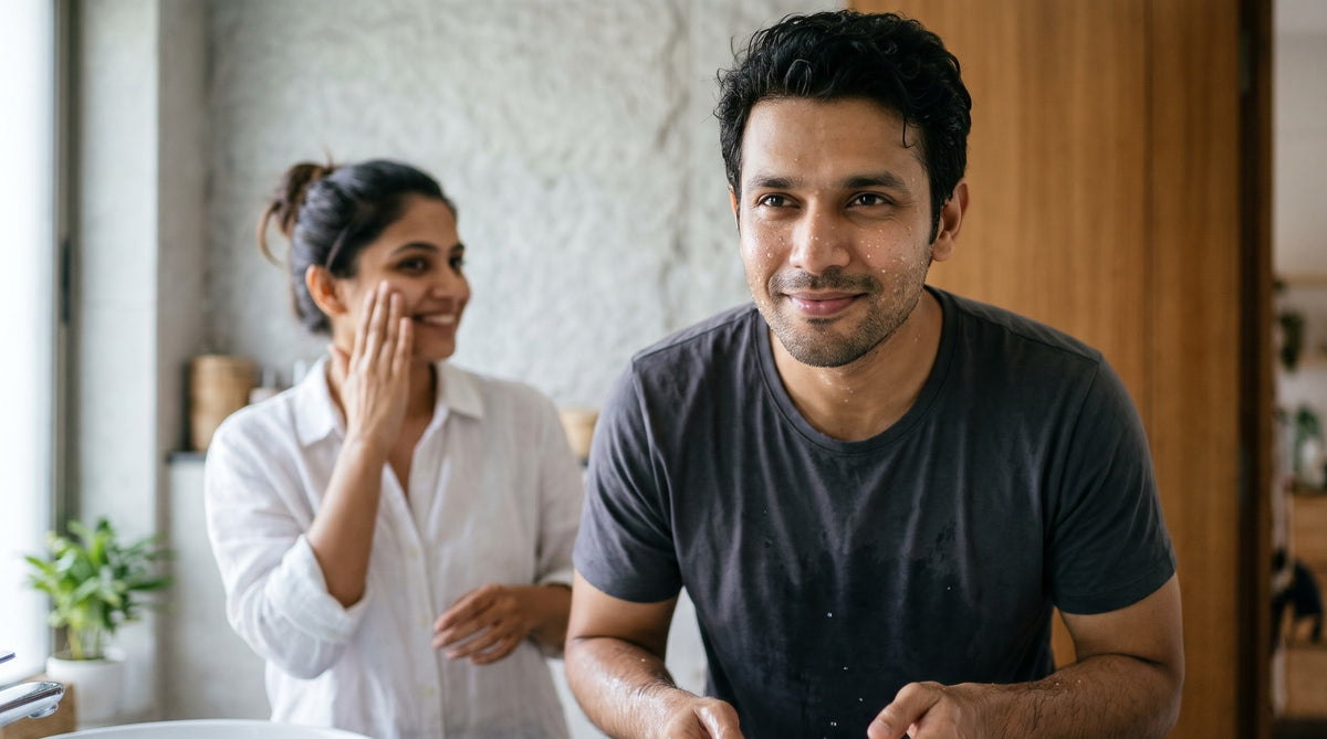 Illustration of a young Indian man with water drops on his face after rinsing at a bathroom basin, with a woman patting moisturizer onto her cheek in the background